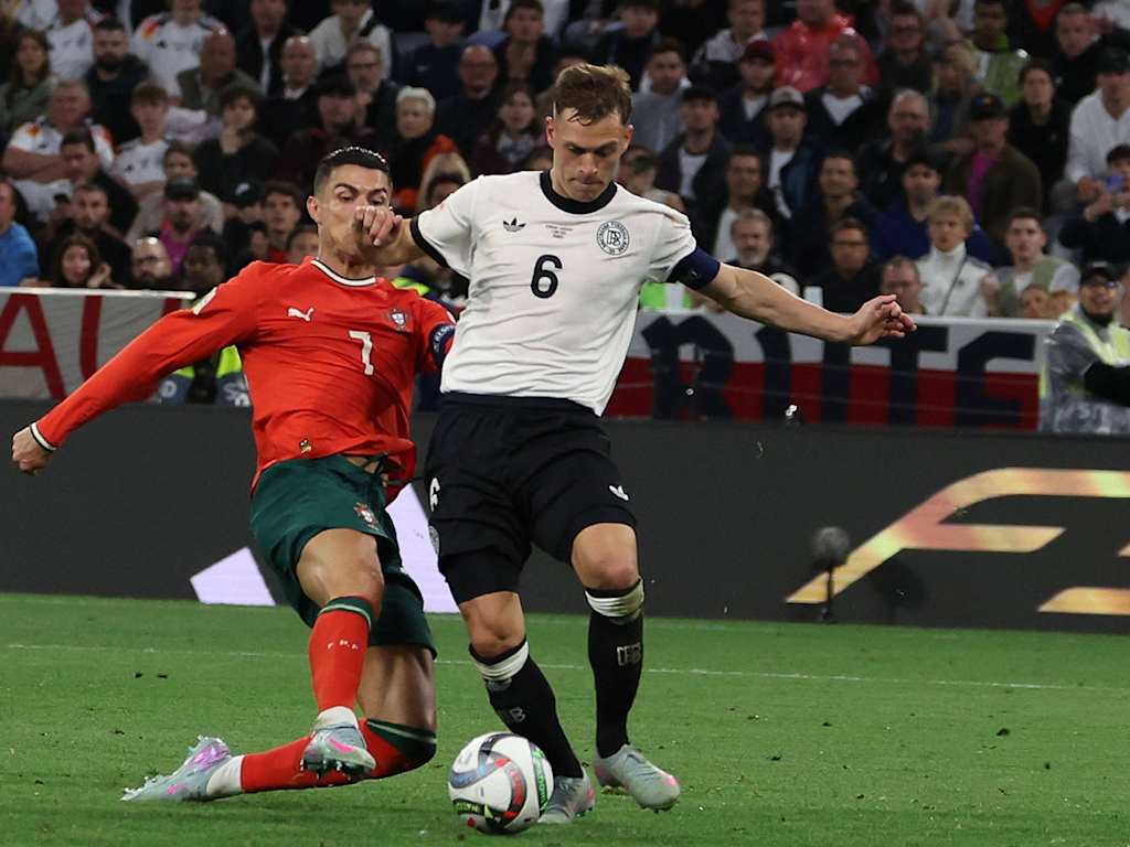 Joshua Kimmich (Germany) on the ball being tackled by Cristiano Ronaldo (Portugal).