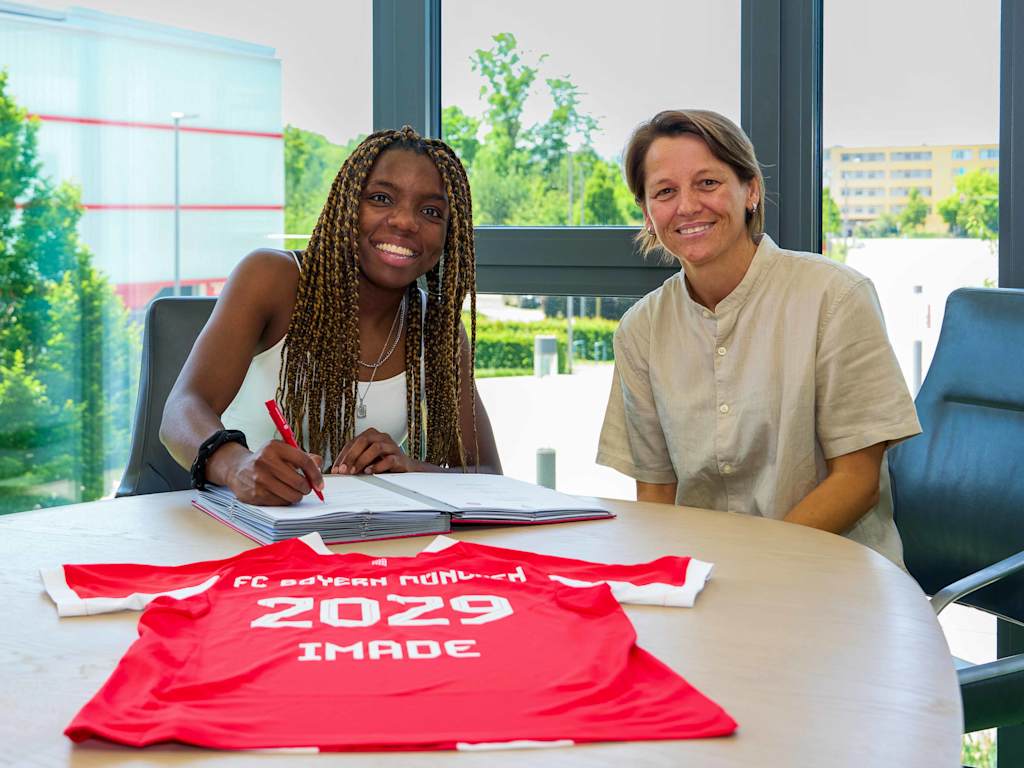 Edna Imade and Bianca Rech sitting as the contract is signed at the FC Bayern Campus.