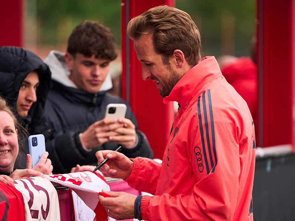 Harry Kane signs fans' shirts at an FC Bayern open training session