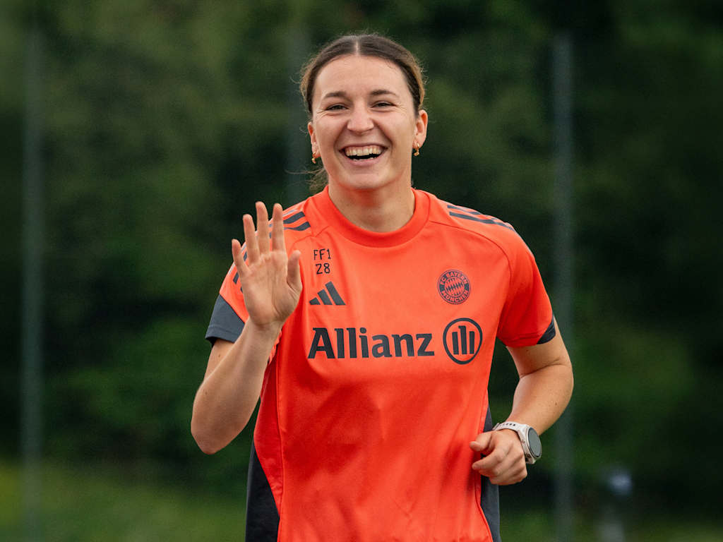 Barbara Dunst lächelt während sie am FC Bayern Campus Runden läuft.