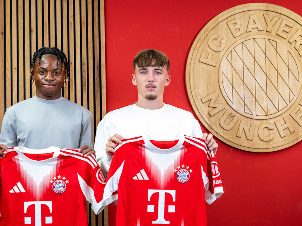 Wisdom Mike and Lennart Karl holding FC Bayern jerseys in front of a red background.