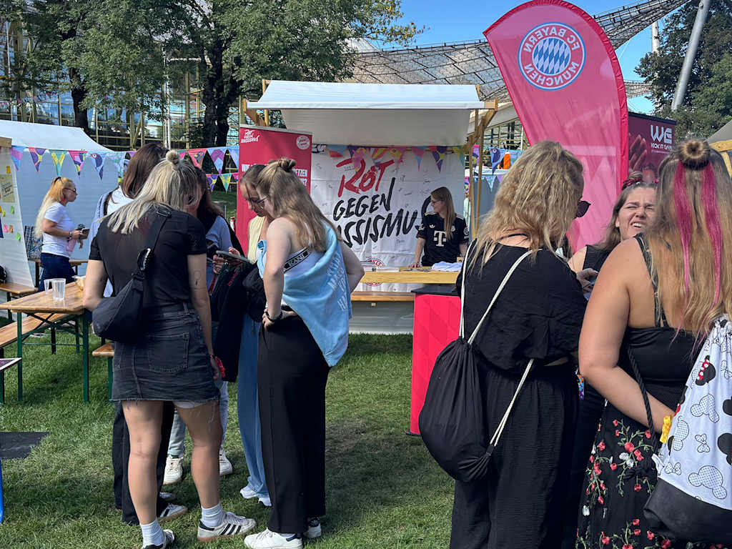 Besucher des Superblooms vor dem Rot-gegen-Rassismus-Stand des FC Bayern