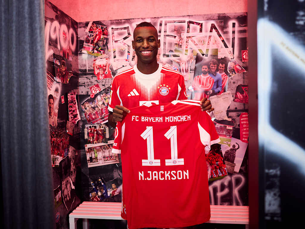 Nicolas Jackson hält ein FC Bayern Trikot mit der Nummer 11 und N. Jackson