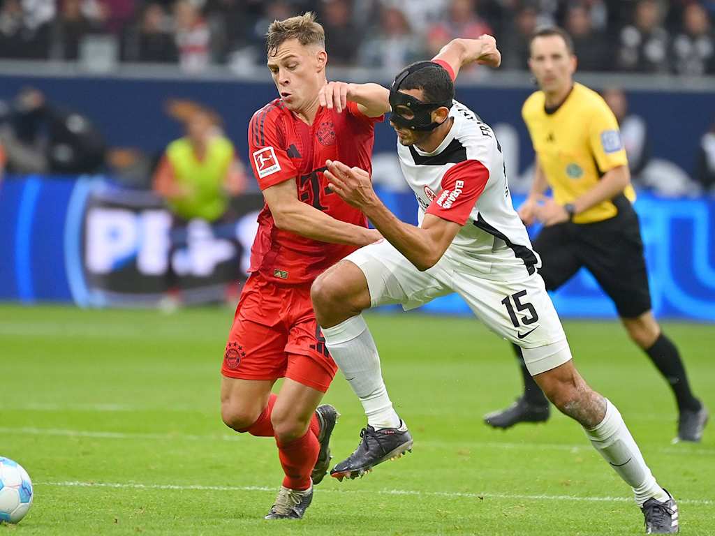 Joshua Kimmich im Zweikampf mit einem Frankfurter Gegenspieler mit Gesichtsmaske.