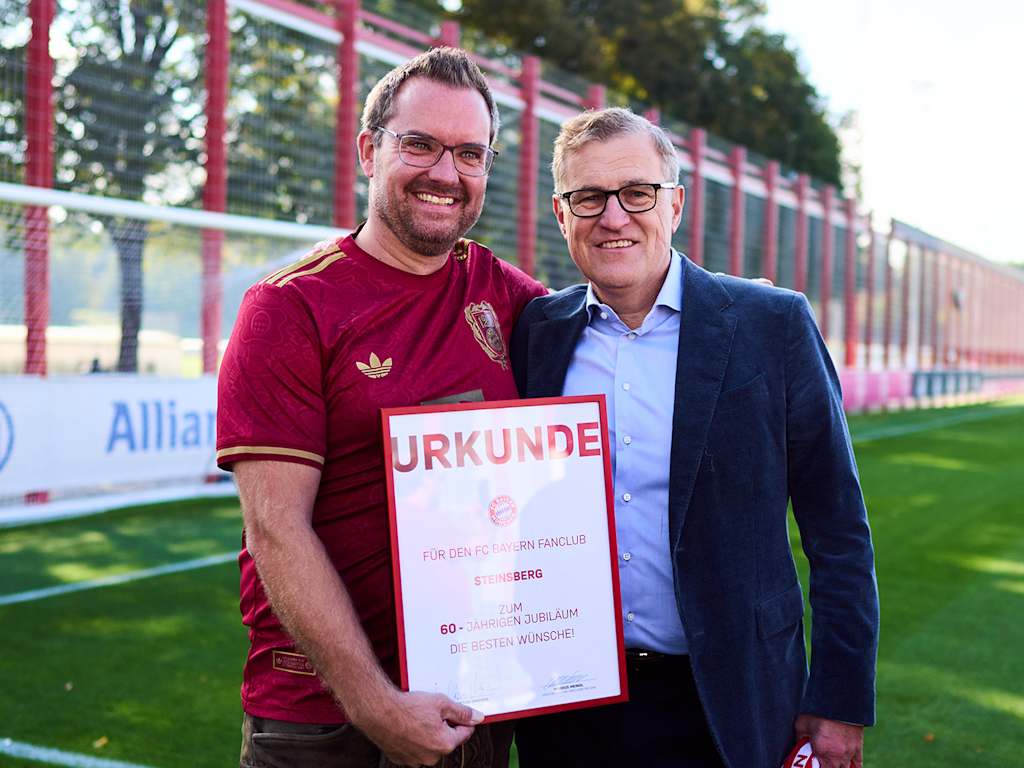 FC Bayern-Vorstandsvorsitzender Jan-Christian Dreesen mit einem Vertreter des Fanclubs Steinsberg auf dem Trainingsplatz des FC Bayern an der Säbener Straße