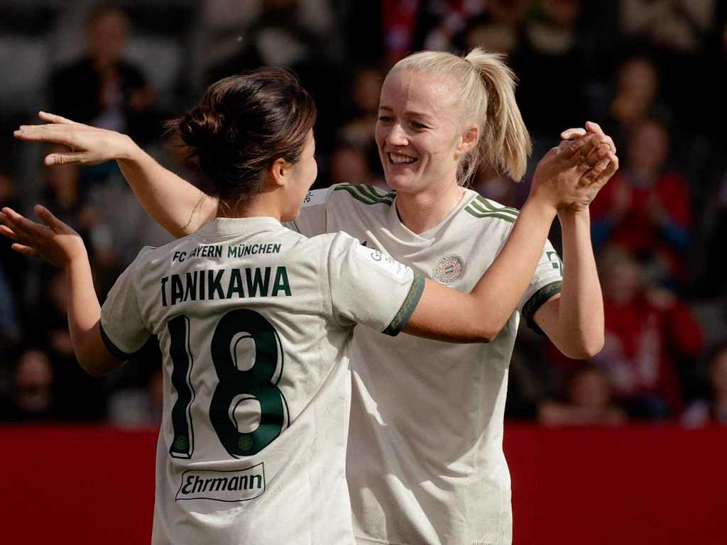 Tanikawa und Schüller klatschen sich nach einem Tor ab und lächeln.