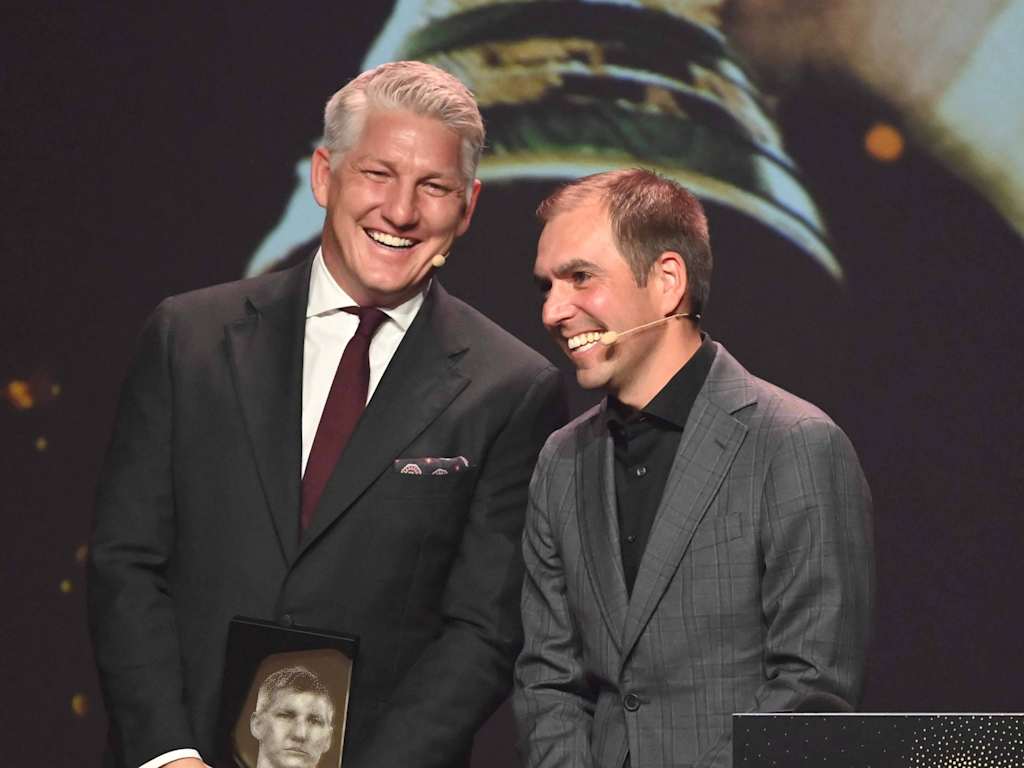 Bastian Schweinsteiger and Philipp Lahm laughing in suits