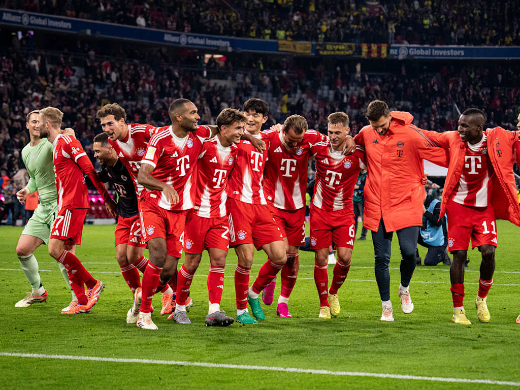 FC Bayern players celebrate with the fans at the Allianz Arena following the win against Dortmund
