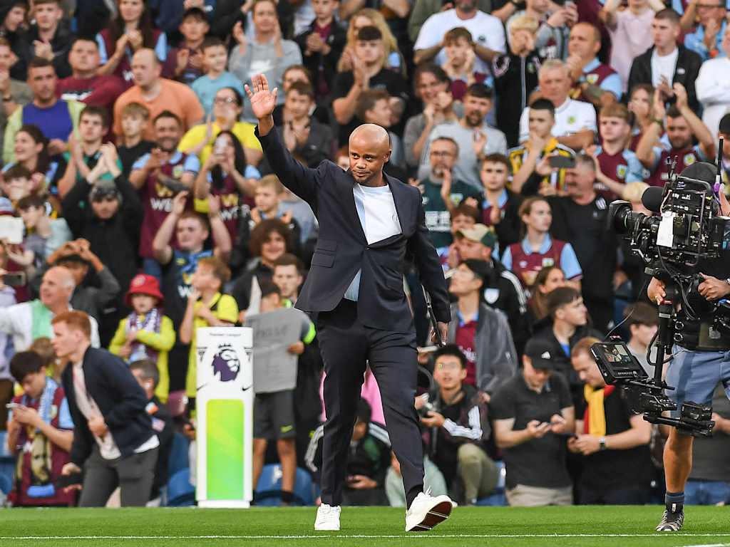 Vincent Kompany im schwarzen Anzug vor einer Menschenmenge im Stadion