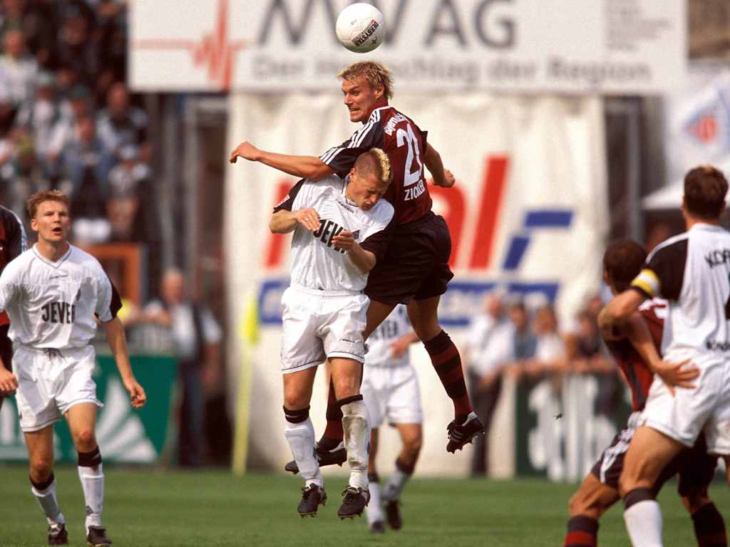 Max Eberl in a Gladbach jersey in an aerial battle with Alexander Zickler in a Bayern jersey.