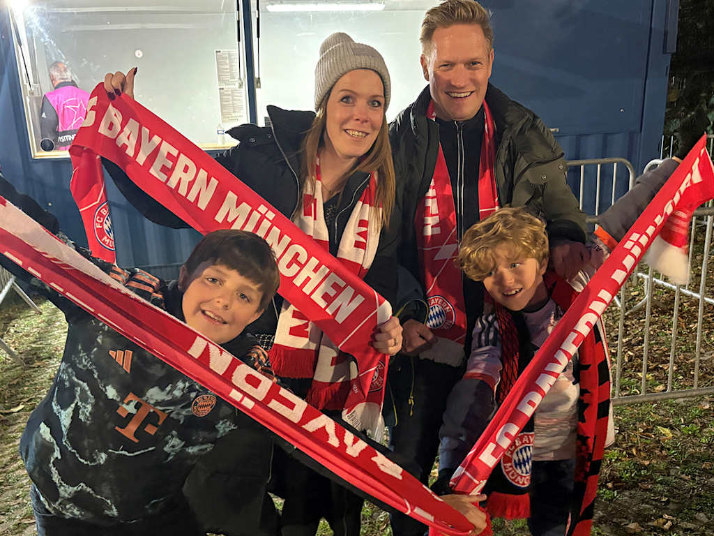 A family of FC Bayern fans holding their scarves