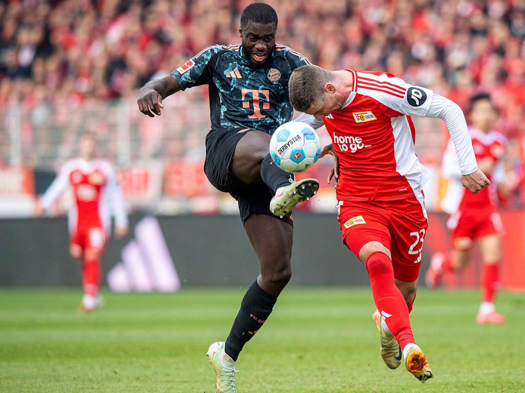 Dayot Upamecano (FC Bayern Muenchen) and Andrej Ilic (1. FC Union Berlin) tussling for the ball