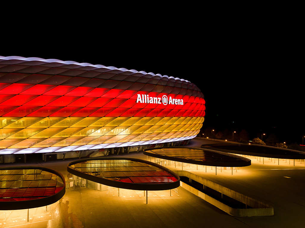 Die Münchner Allianz Arena bei Nacht in den Farben schwarz, rot und gold.