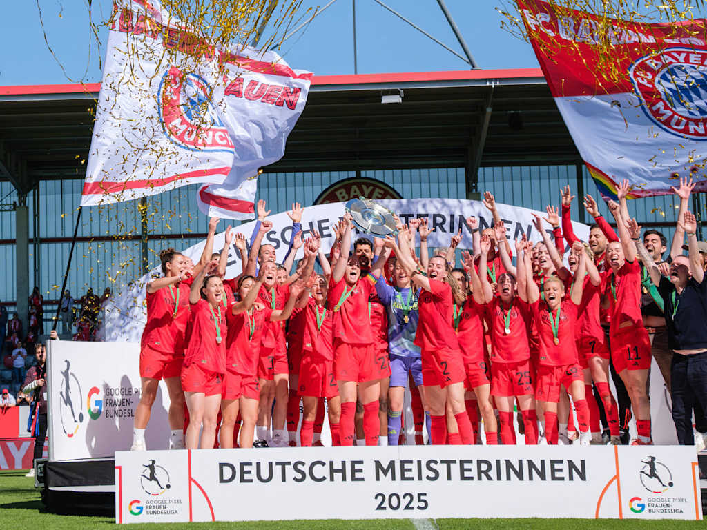 FC Bayern Women being presented with the Meisterschale and hoisting it into the air.