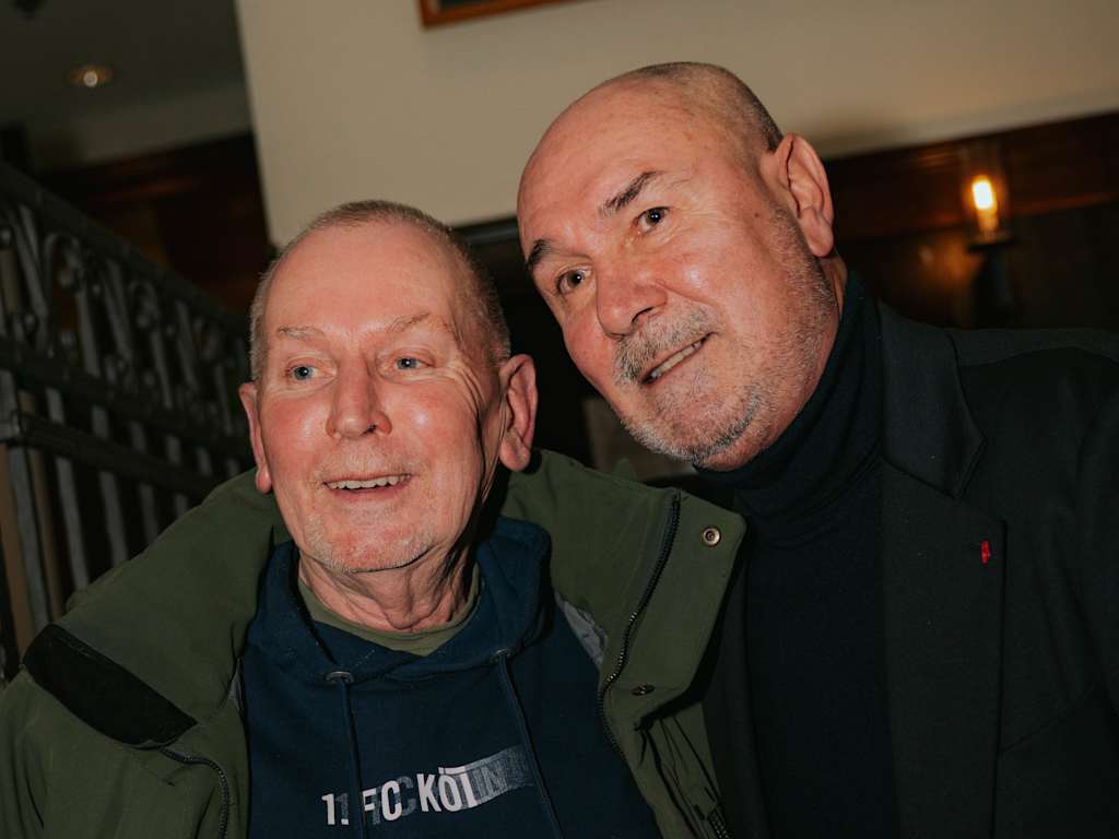 Raimond Aumann poses for a photo with a fan.