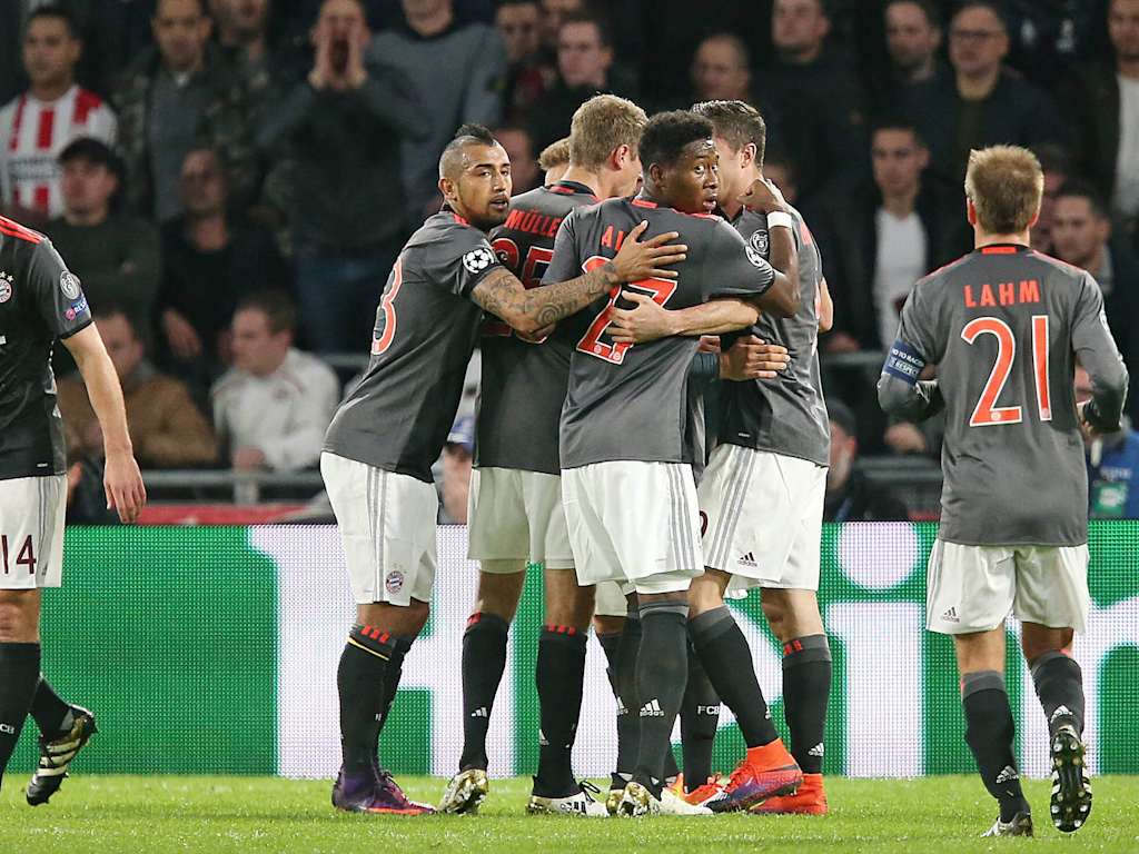 Players celebrating in black jerseys surround David Alaba and Arturo Vidal in Eindhoven.