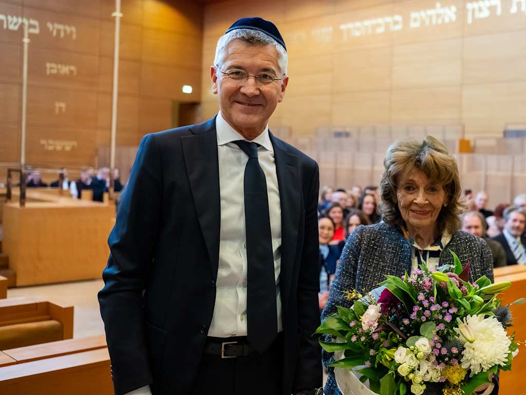 Herber Hainer and Charlotte Knobloch in a synagogue in Munich, Knobloch holding flowers