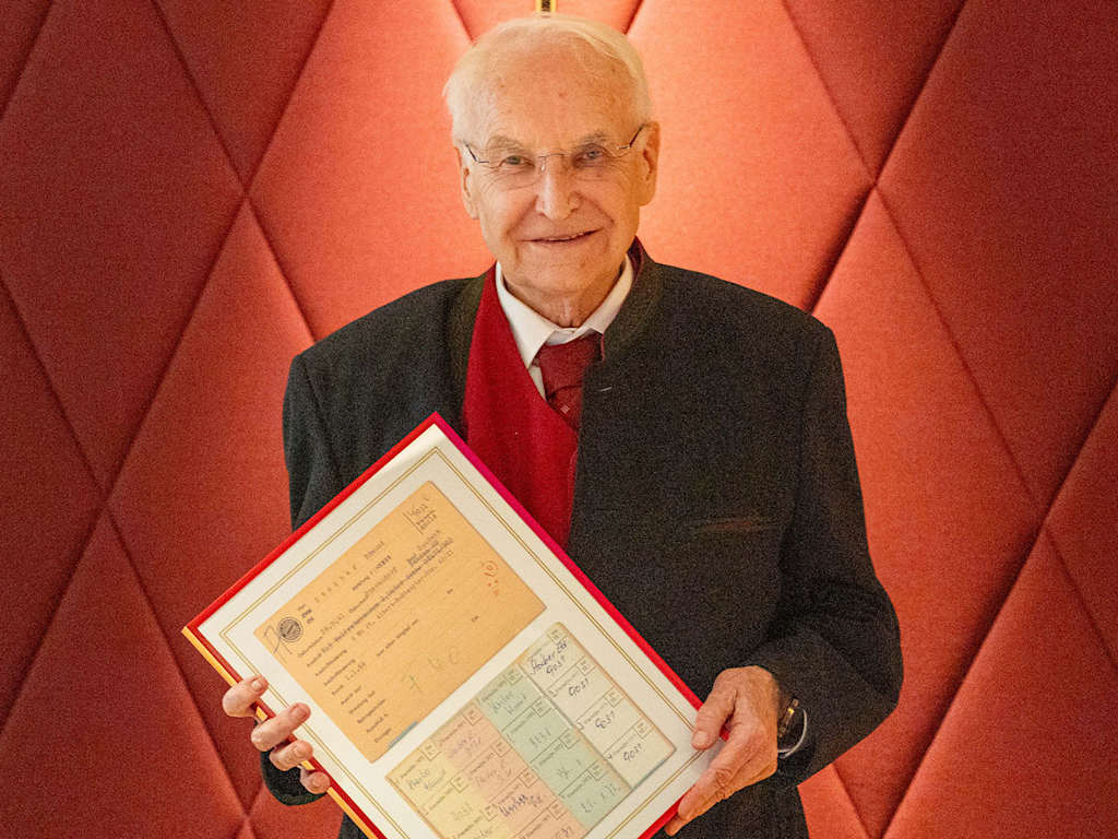 Edmund Stoiber hält eine Urkunde in der Hand