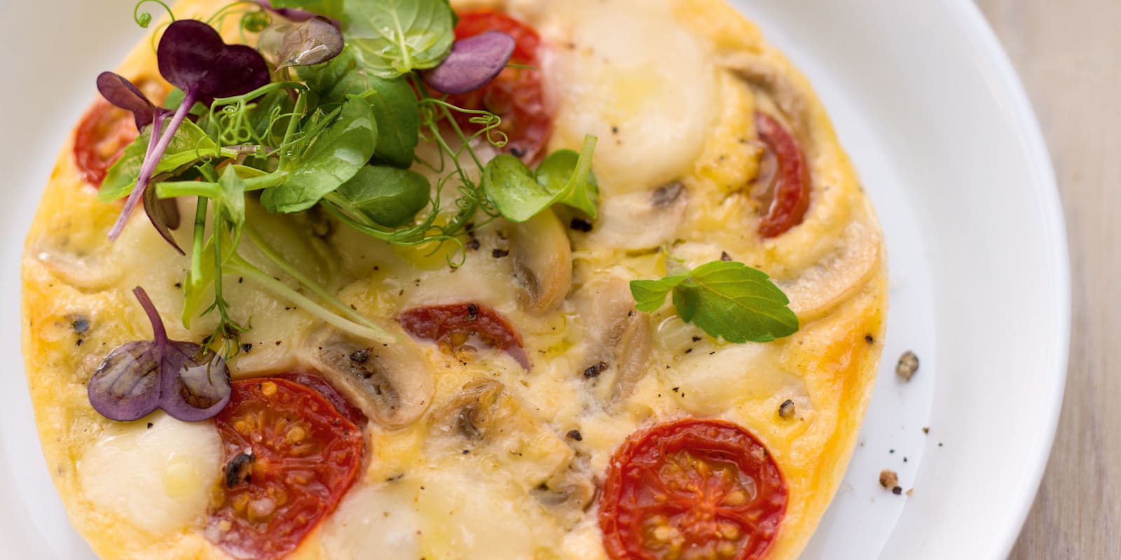 Offenes Omelett mit Tomate, Mozzarella und Kräutersalat