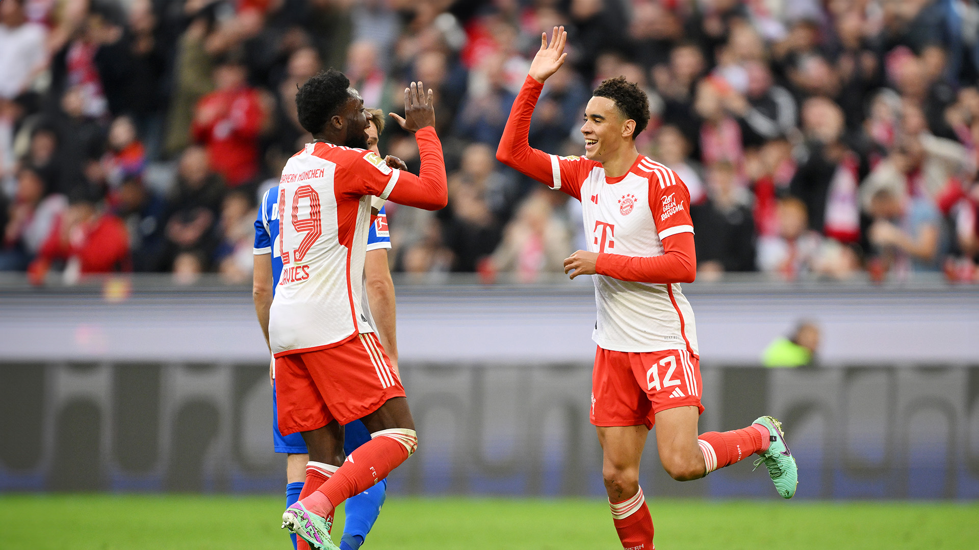 Alphonso Davies and Jamal Musiala celebrate a Bayern goal against Darmstadt.