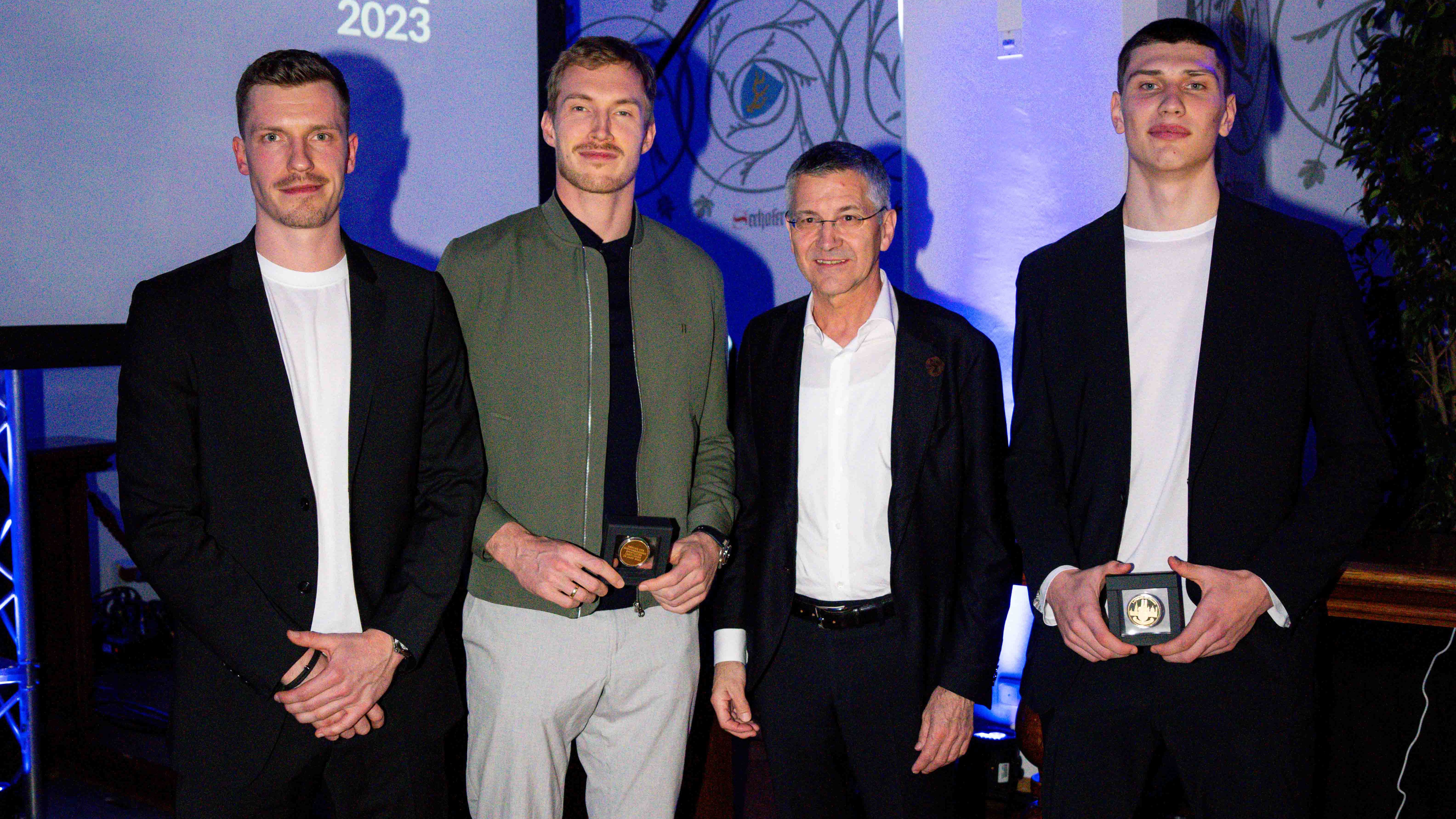 FC Bayern-Präsident Herbert Hainer mit Andreas Obst, Niels Giffey und Ivan Kharchenkov von den FC Bayern Basketballern.