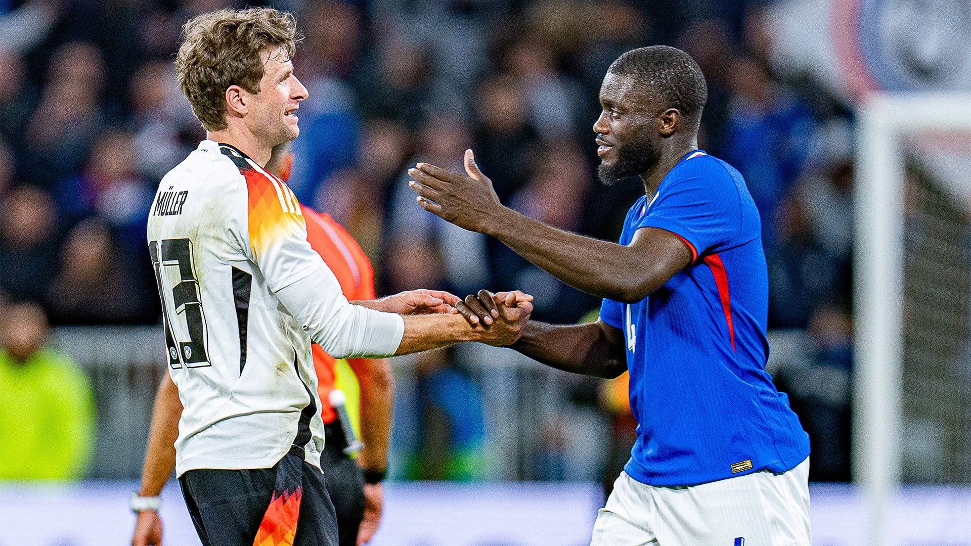 Thomas Müller und Dayot Upamecano klatschen sich nach dem 2:0-Sieg des DFB-Teams über Frankreich ab.