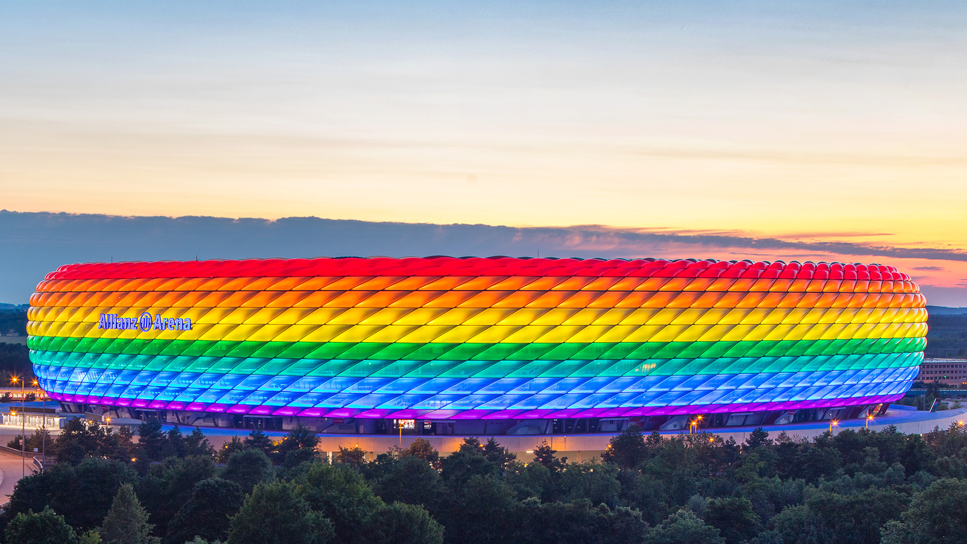 Die Allianz Arena des FC Bayern erstrahlt in den Abendstunden in Regenbogenfarben.