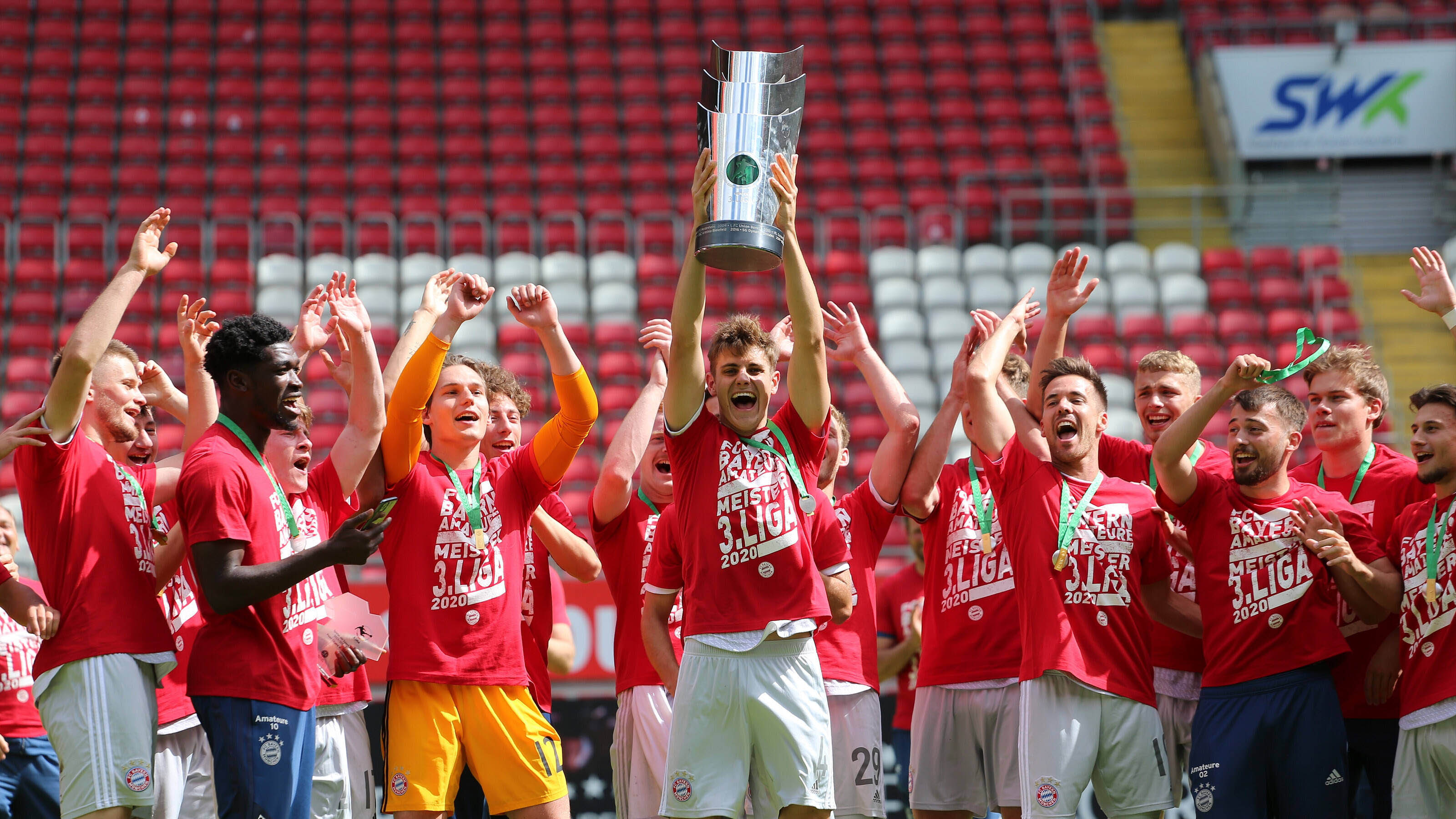 Josip Stanišić lifts the 3. Liga trophy in the air in Kaiserslautern.