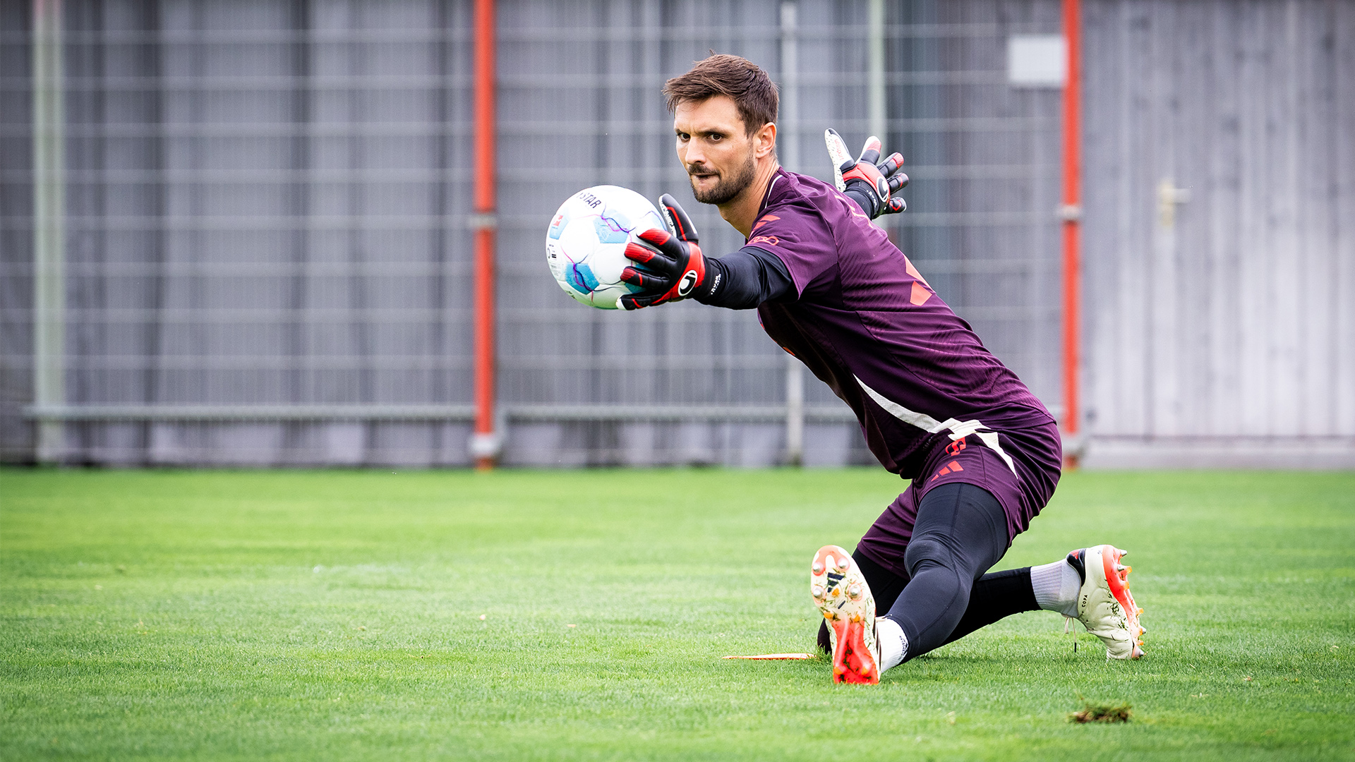 Torwart Sven Ulreich pariert einen Ball in der Hocke im FC Bayern-Training