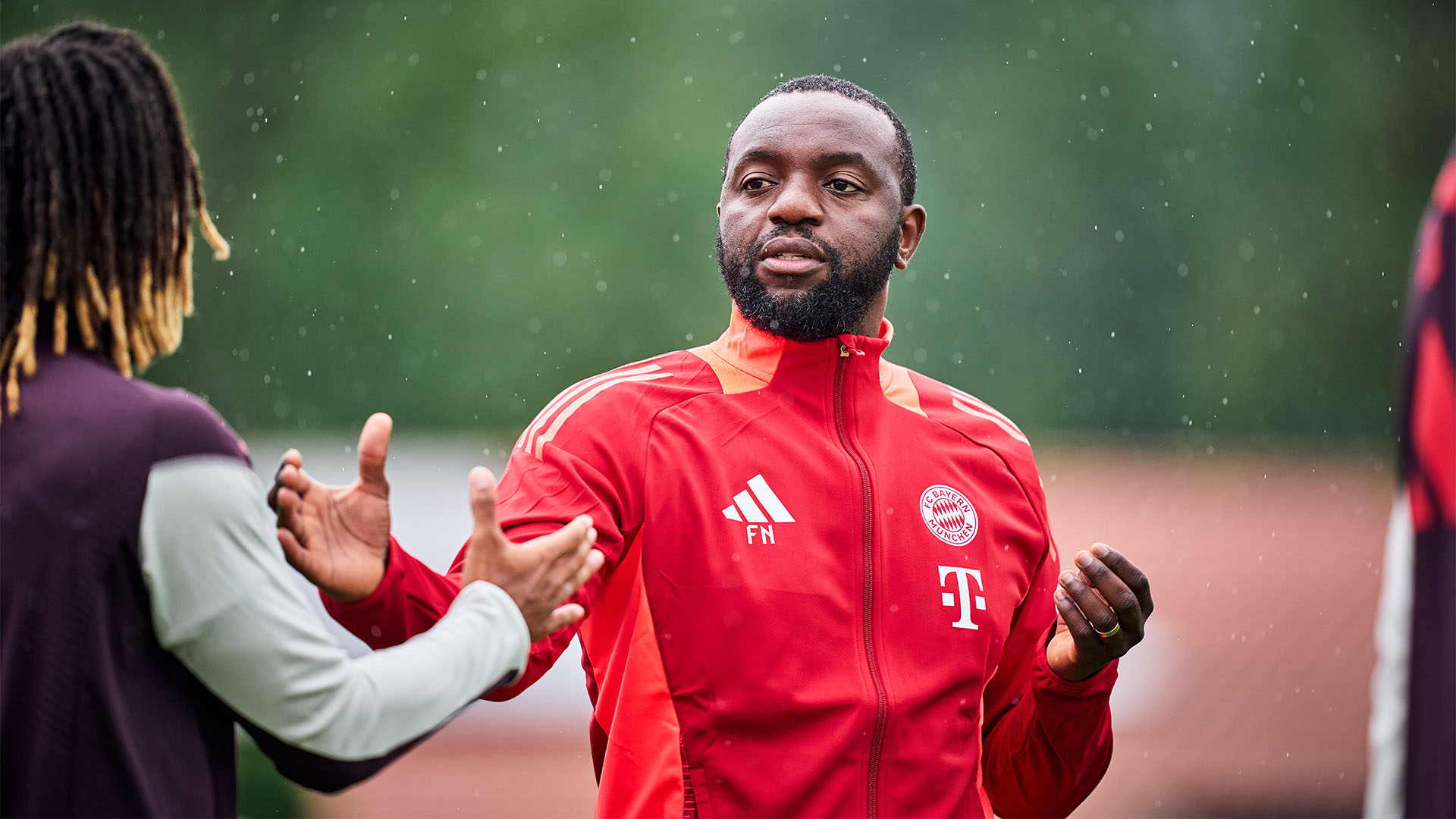 Co-Trainer Flotibert N'Galula gibt einem Spieler im Training des FC Bayern die Hand.