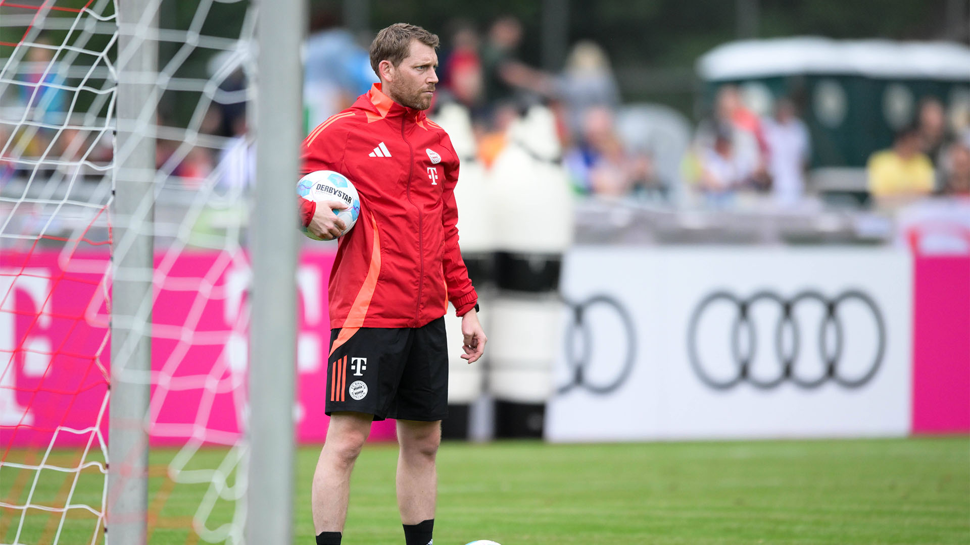 Torwarttrainer Michael Rechner hält einen Ball in der Hand und beobachtet das Training des FC Bayern.