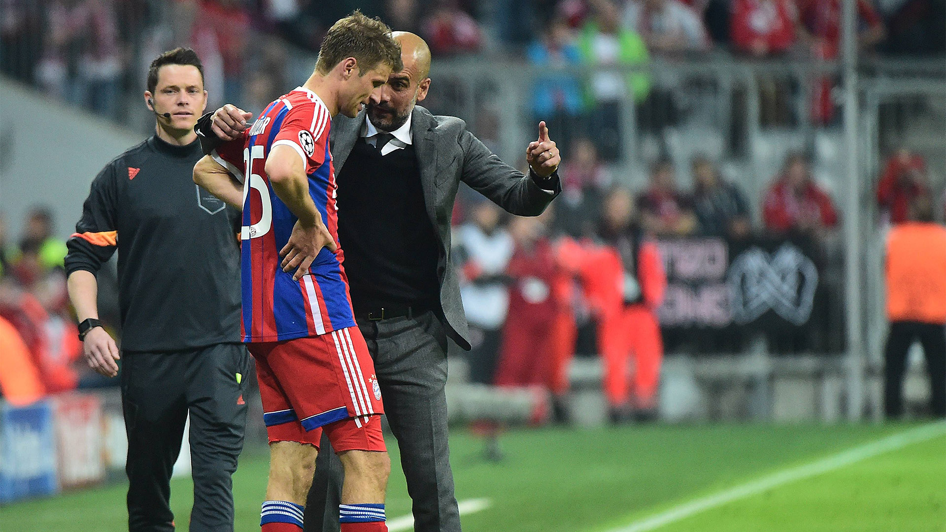 Pep Guardiola spricht mit Thomas Müller an der Seitenlinie während einer Partie des FC Bayern