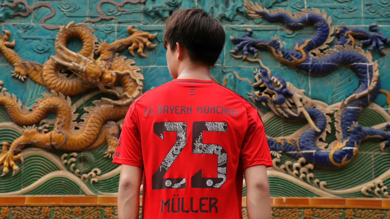 Ein Model posiert mit dem Dragon Flock des FC Bayern.