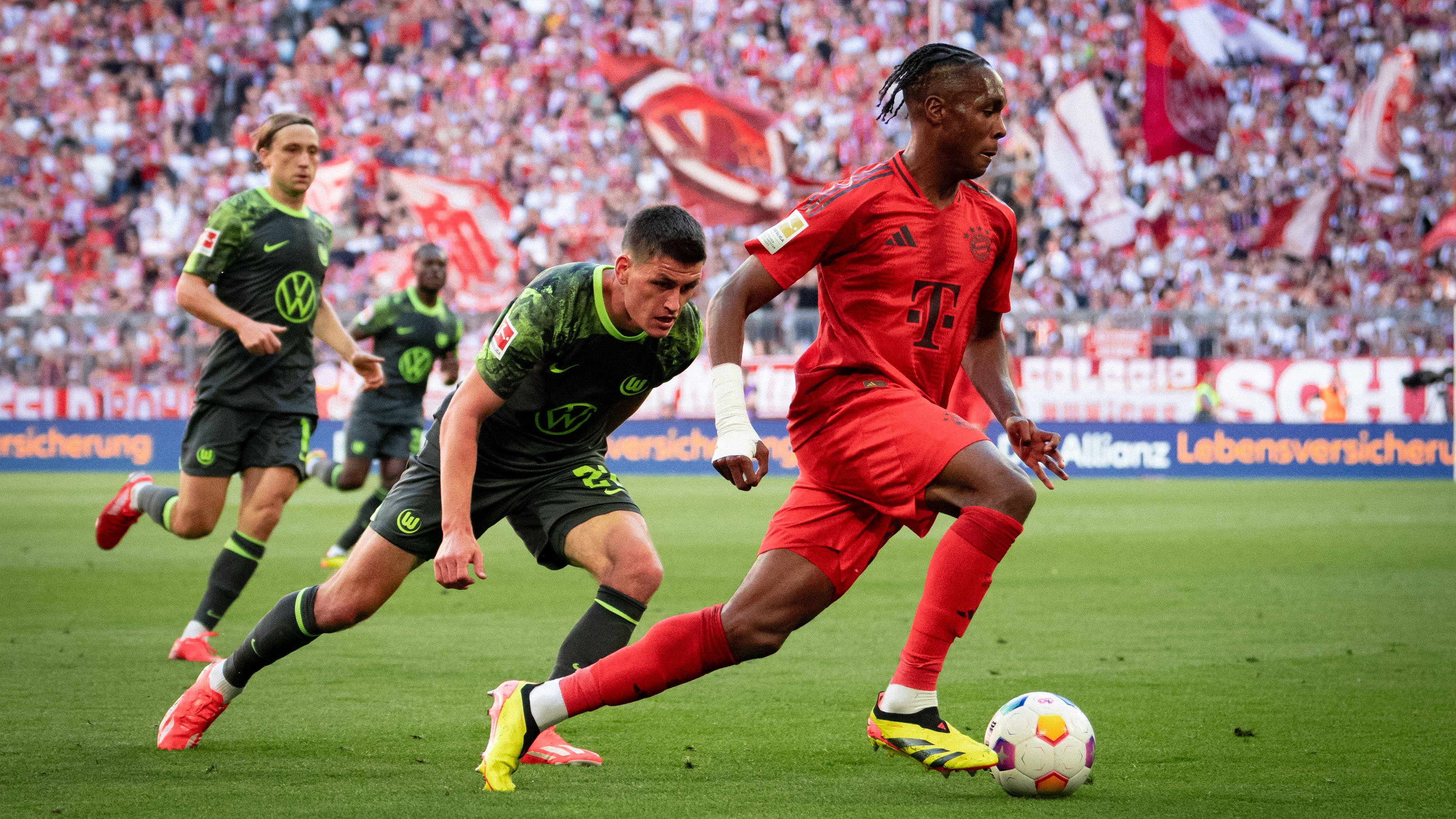 Mathys Tel in a tussle against VfL Wolfsburg