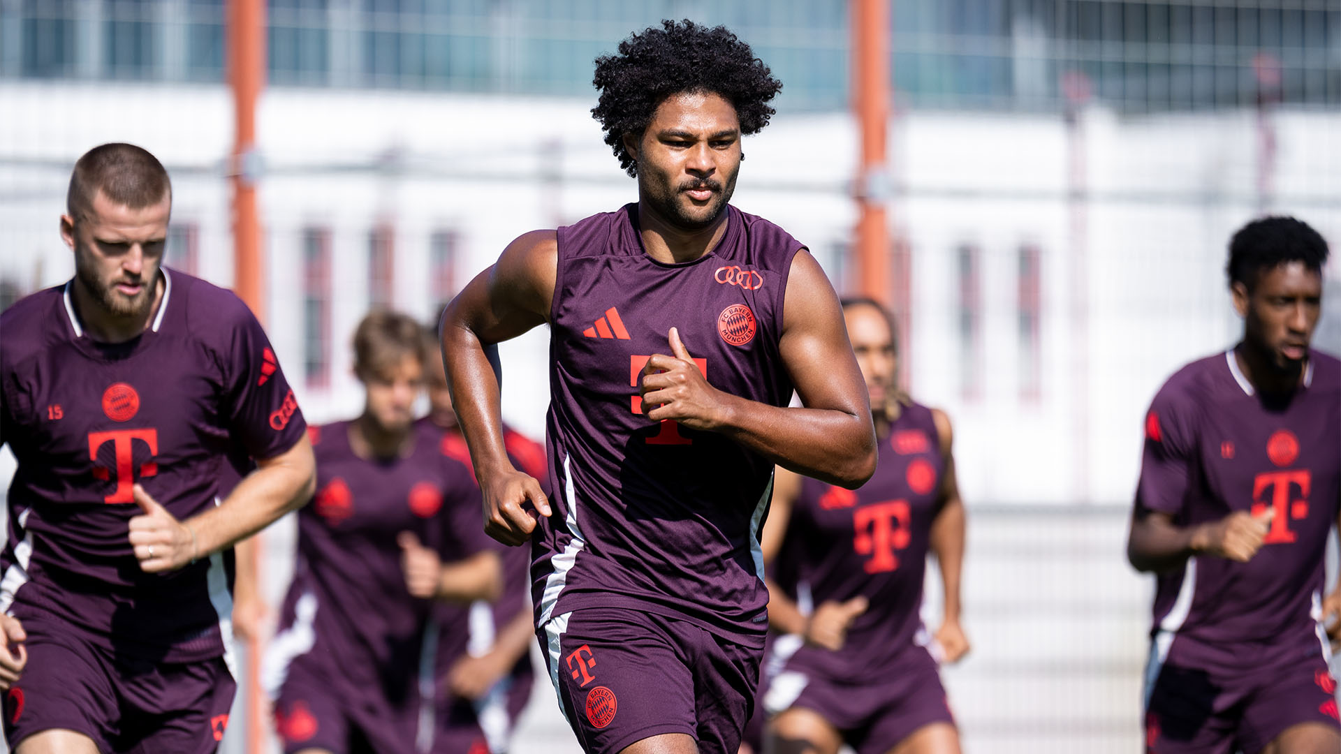 Serge Gnabry läuft sich mit seinen Teamkollegen im Training des FC Bayern warm.