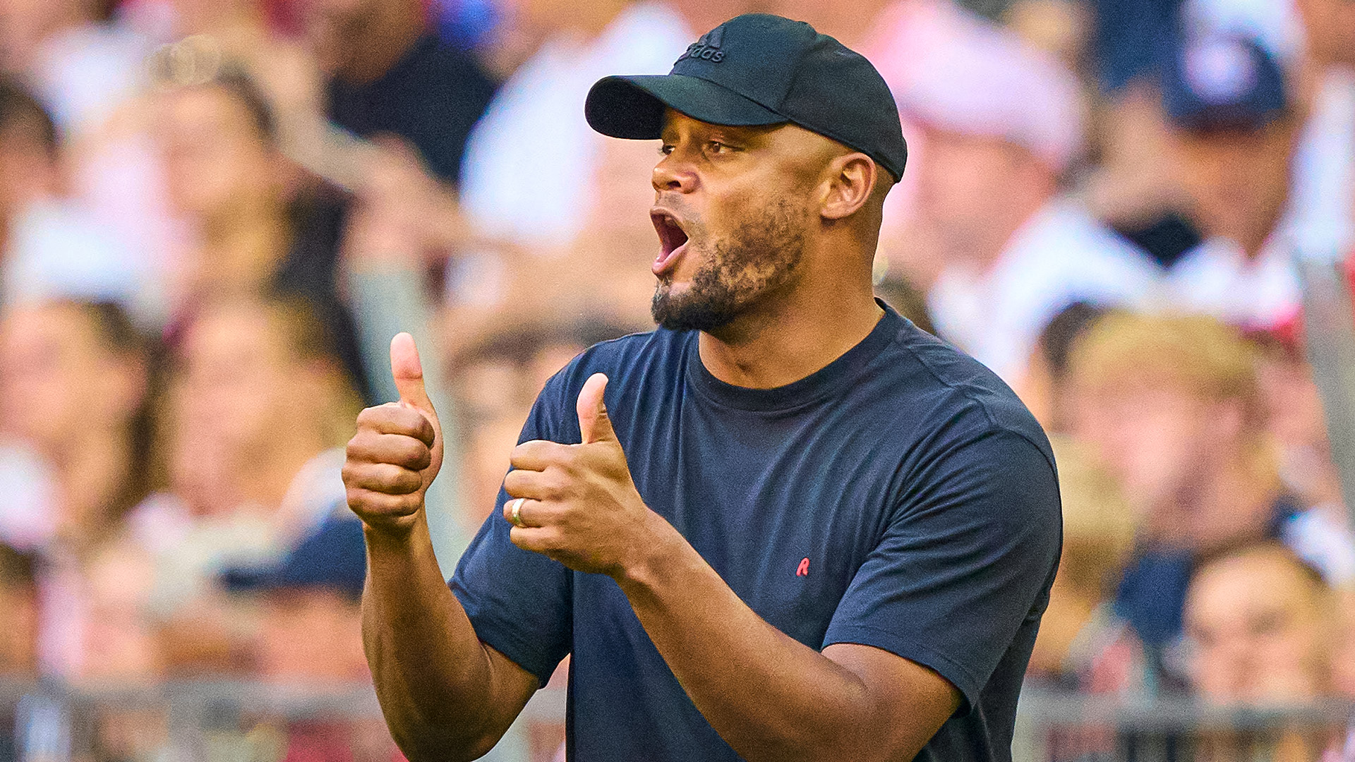 Coach Vincent Kompany gives a thumbs-up on the touchline.