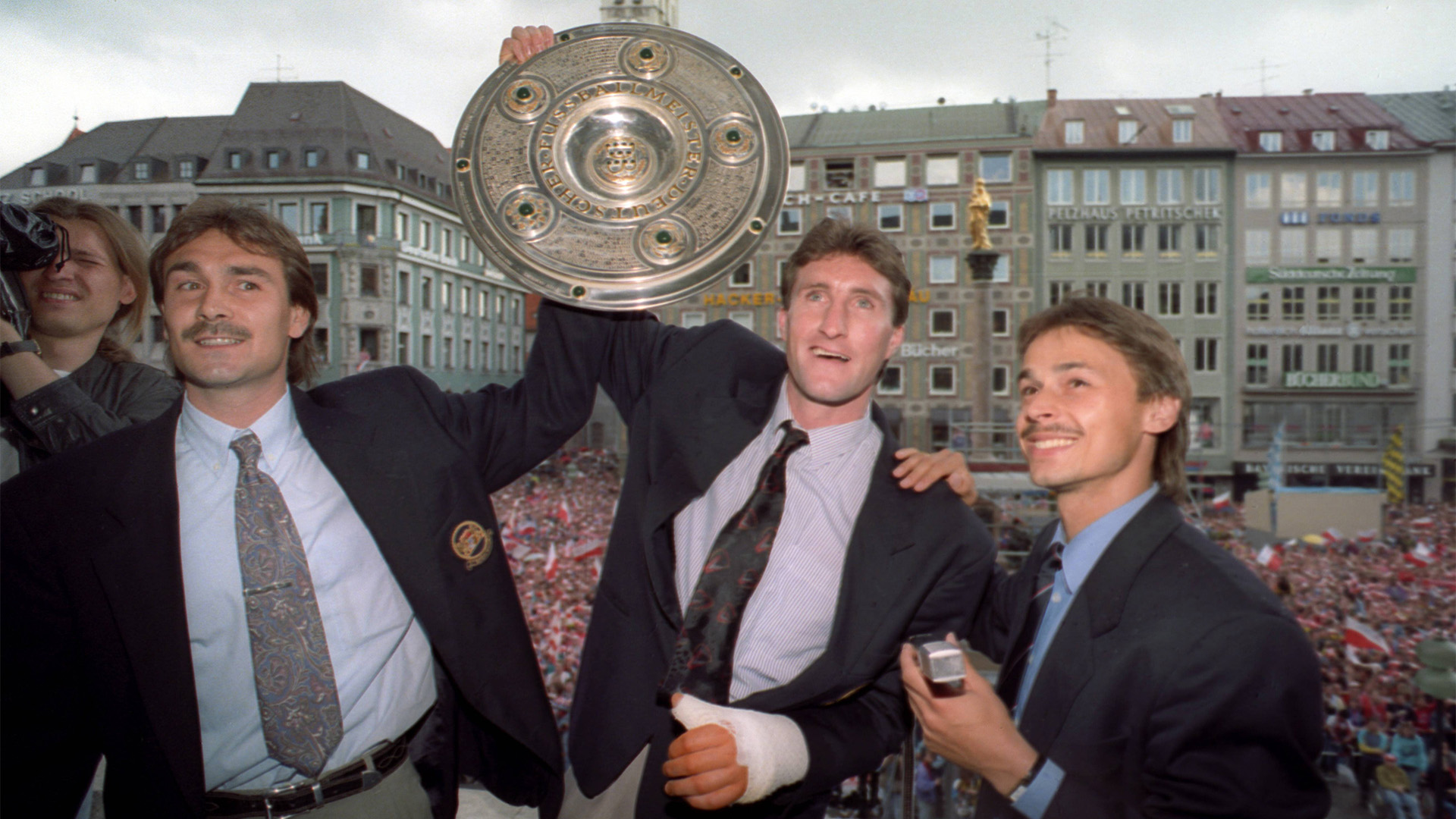 Los jugadores del Bayern Aumann, McInally y Thon con el trofeo de campeón en la Marienplatz.