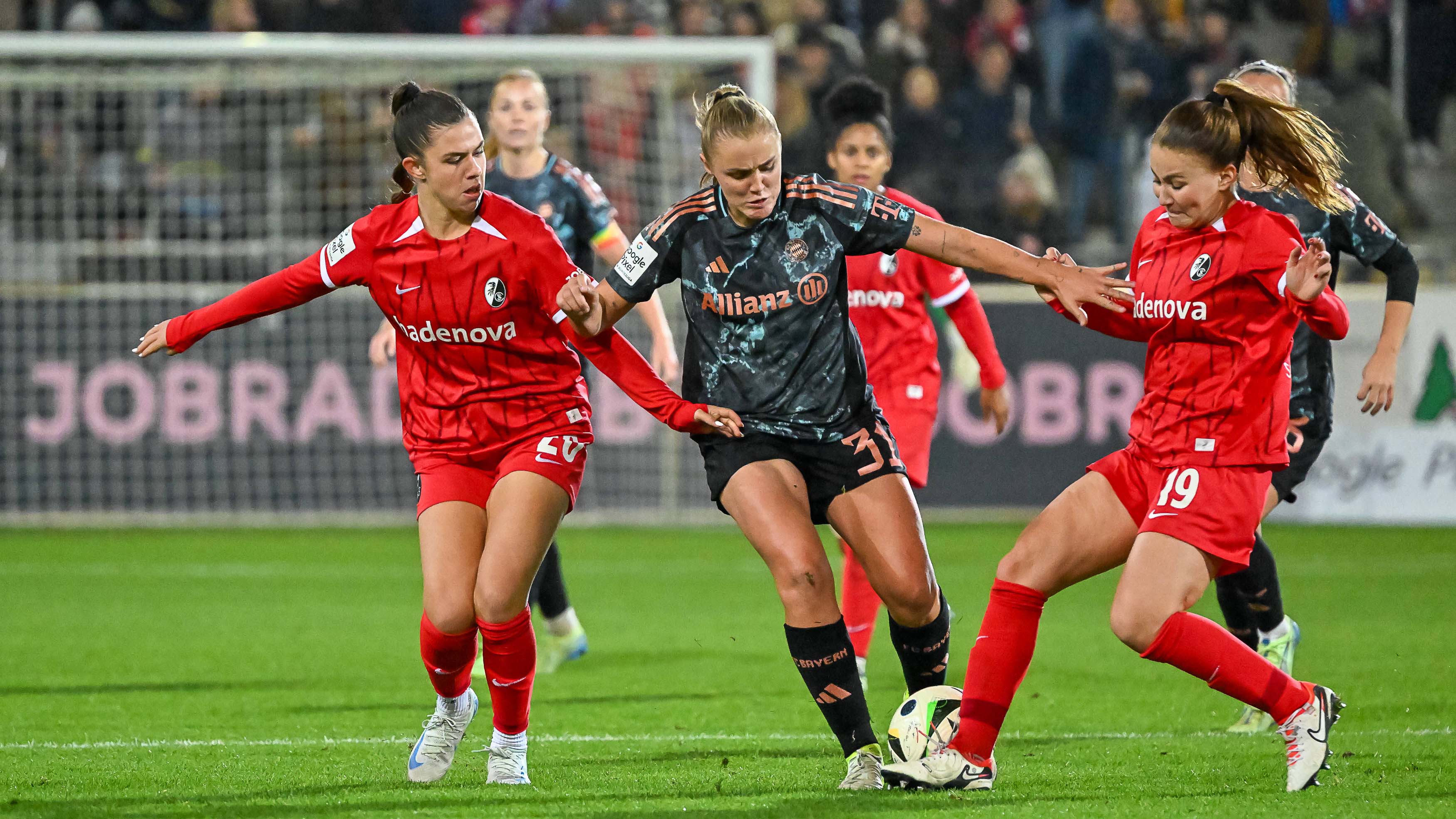 Georgia Stanway im Spiel der FC Bayern Frauen gegen den SC Freiburg im Kampf um den Ball in der Mitte von zwei Gegenspielerinnen