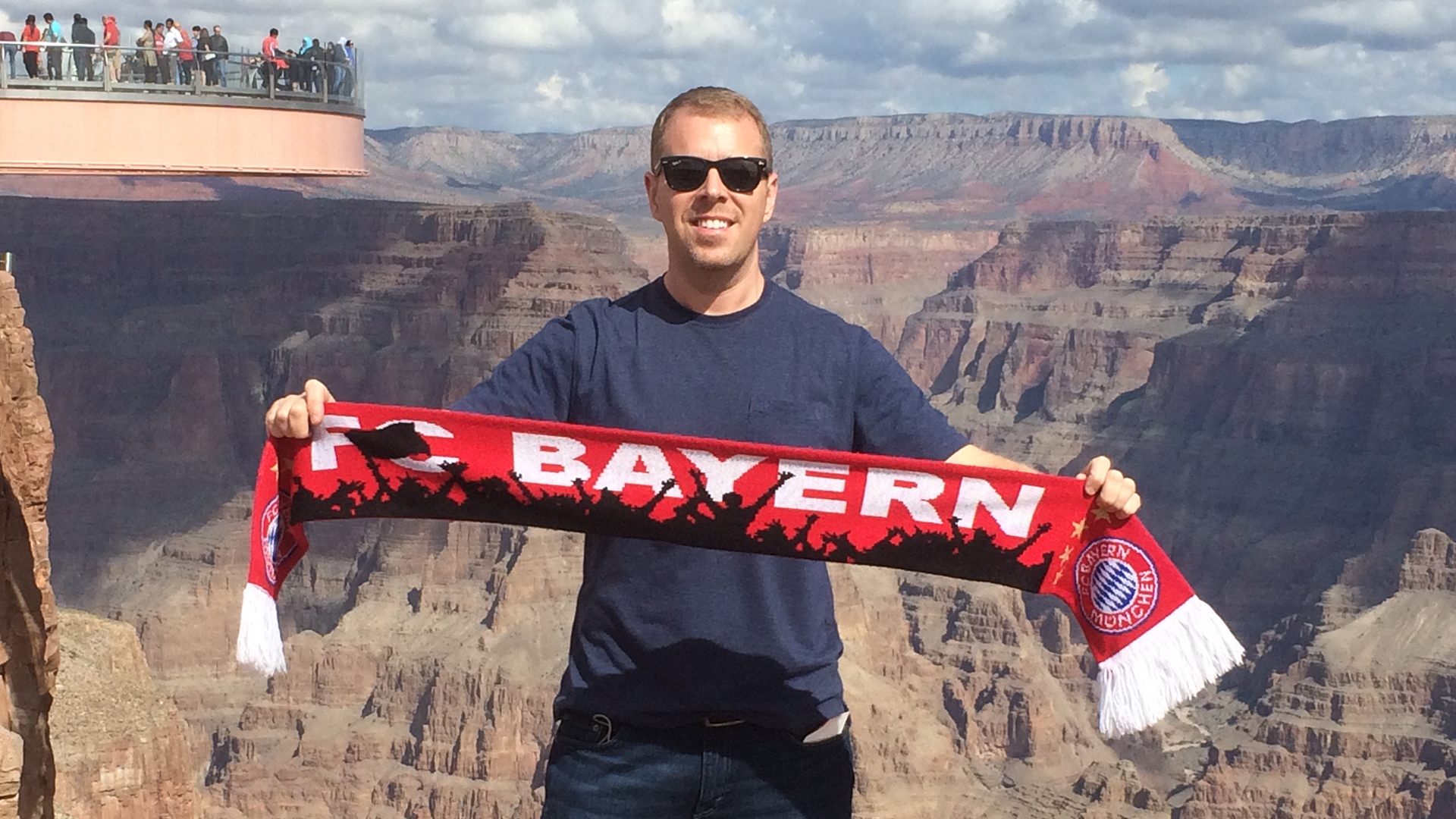 FC Bayern-Fan Thor hält einen Schal in die Höhe.