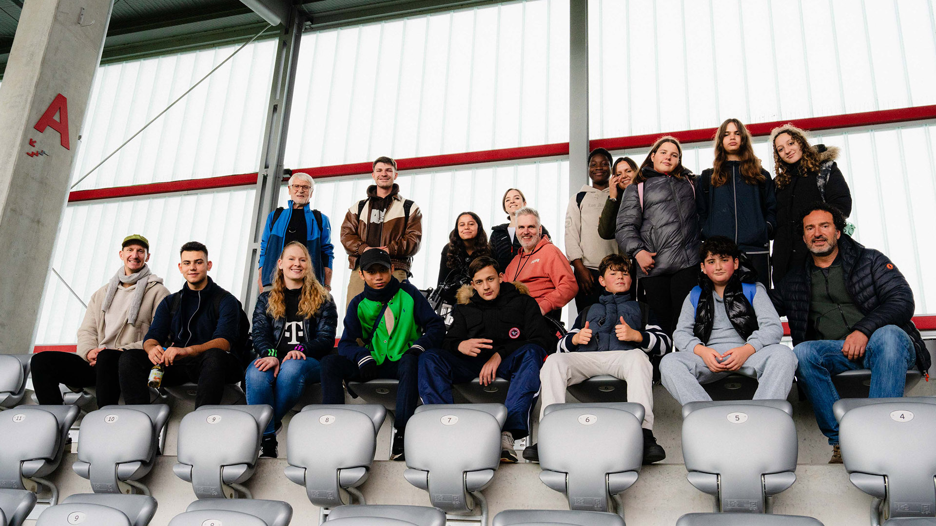 Gruppenbild Teilnehmer Inklusions-Workshop auf der Tribüne der Spielstätte am FC Bayern Campus