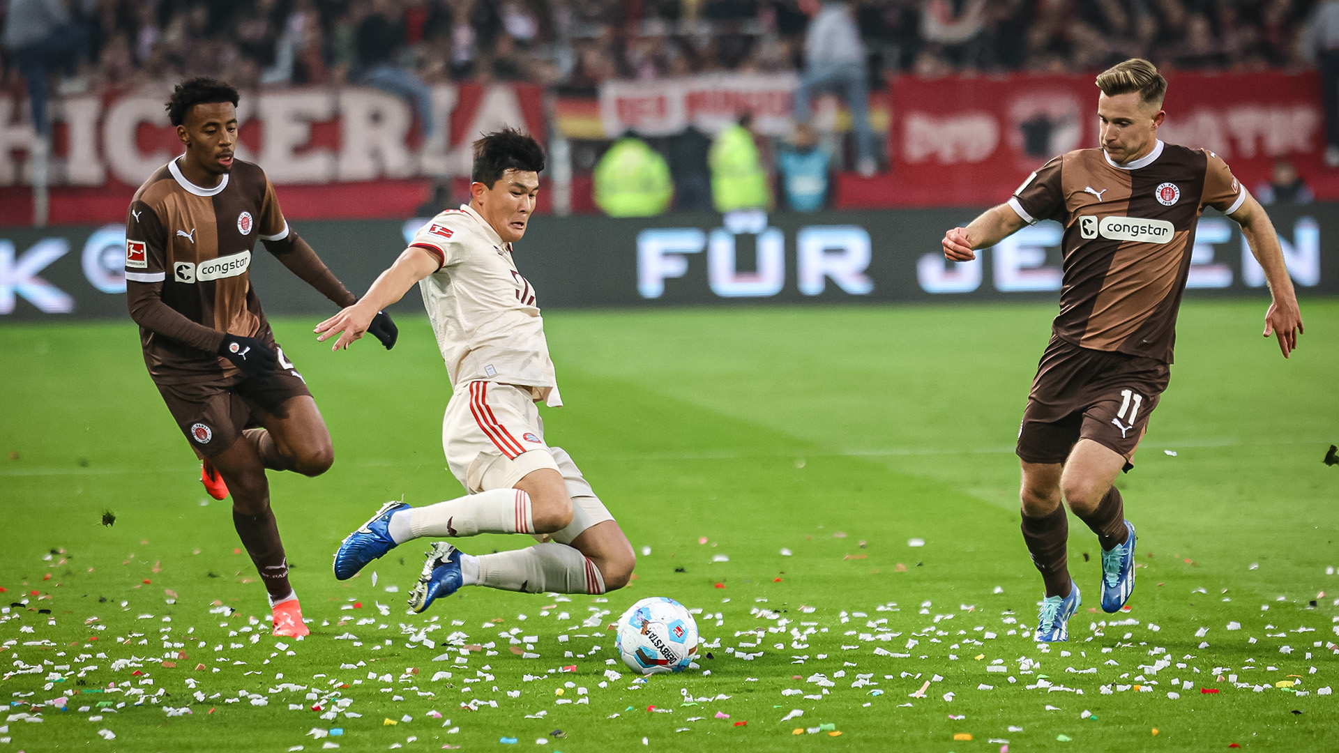 Minjae Kim flies into a tackle during the match at FC St. Pauli