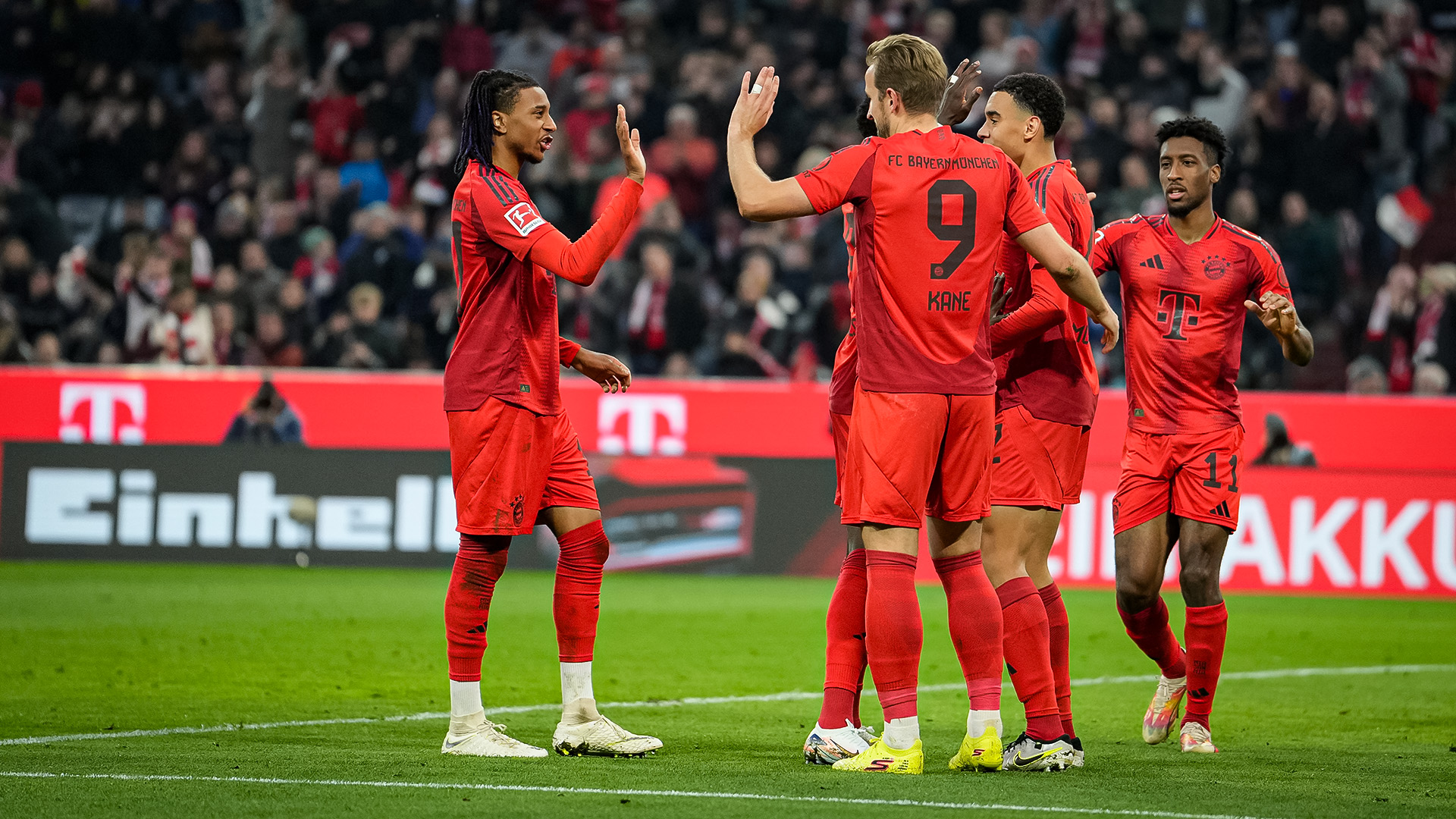 Michael Olise, Harry Kane and their teammates high-five each other after an FC Bayern goal against Union Berlin.