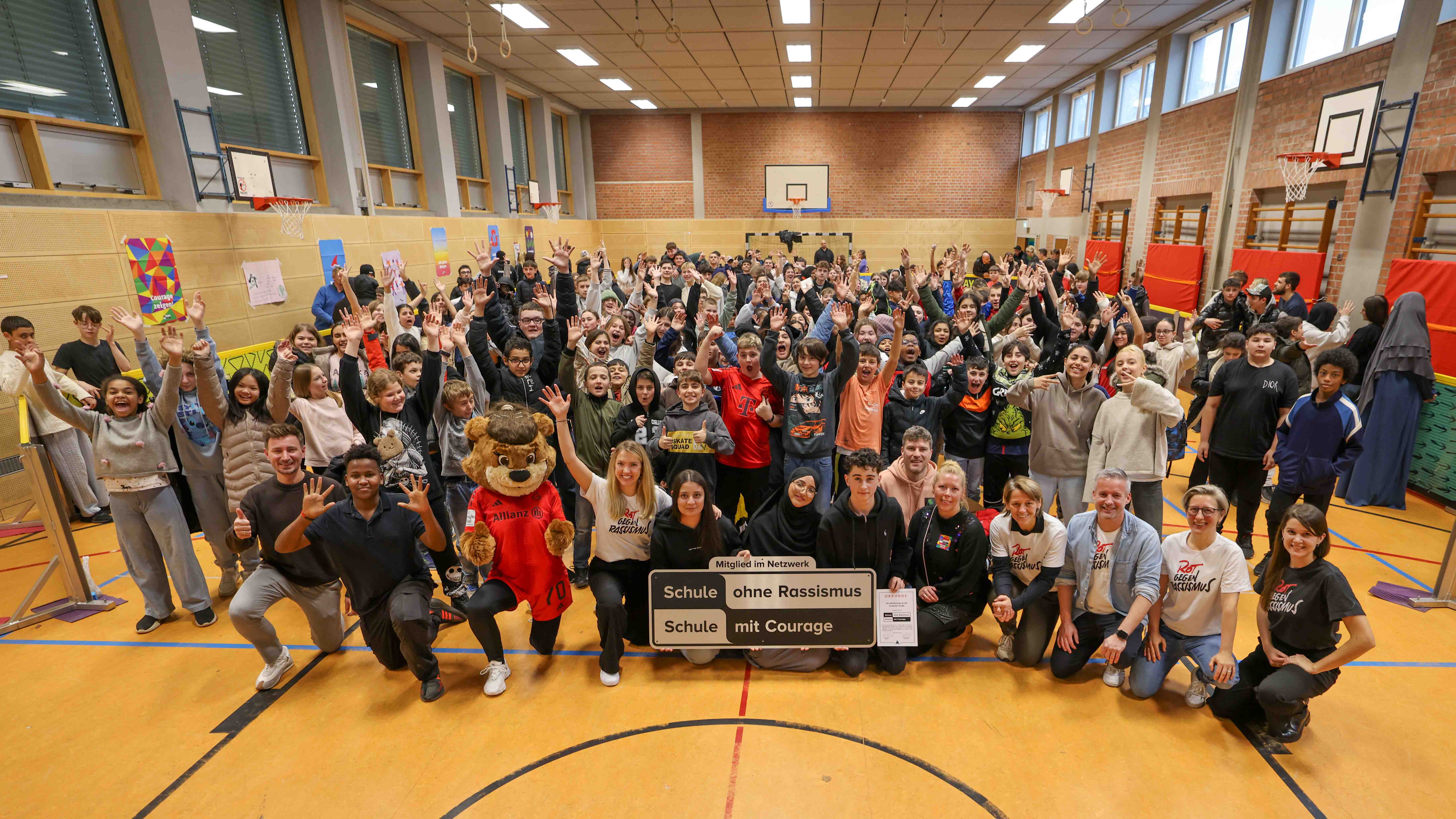 Die Verantwortlichen der FC Bayern Frauen auf einem Gruppenfoto an der Patenschule