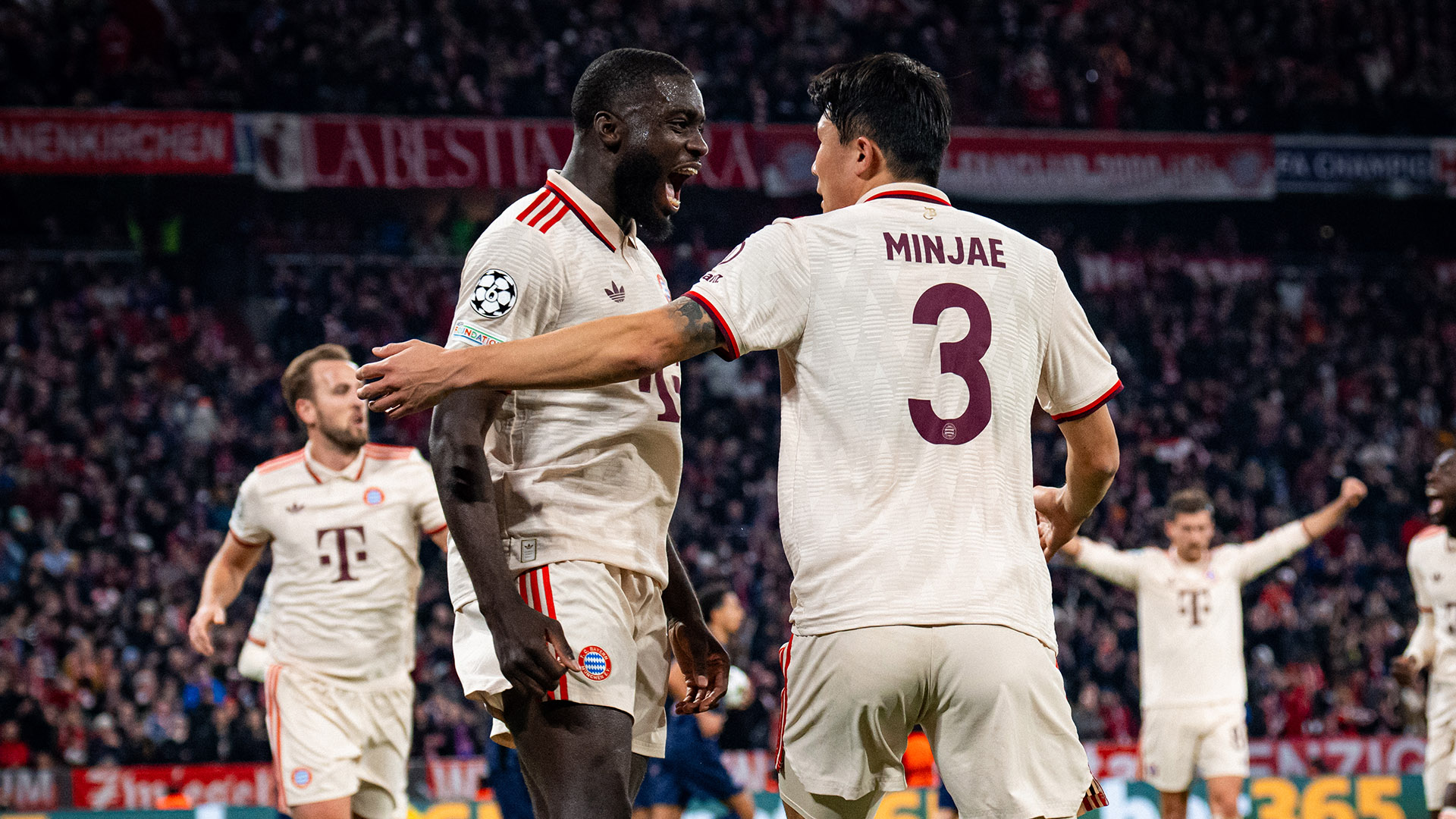 Dayot Upamecano celebrates with Minjae Kim after FC Bayern's goal against Paris Saint-Germain